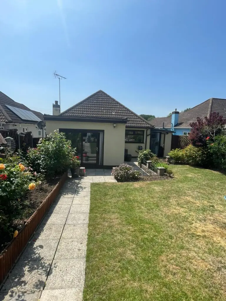 Rear garden view of a tidy residential bungalow following a professional loft spray foam removal service by Smart Spray Foam Removal in Surrey.